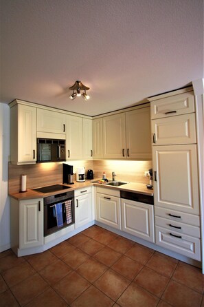 A kitchen with white cabinets, a microwave, a coffee maker, and a dishwasher. - Palais am Südstrand - Whg. 2 - Holiday apartment on the south beach: close to the beach and (Wyk auf Föhr)