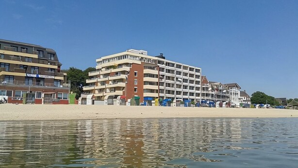 A beachfront hotel with multiple floors, balconies, and a sandy beach in the foreground. - Mühlenblick - Apartment Mühlenblick: 60 m² near the beach in Wyk auf Föhr (Wyk auf Föhr)