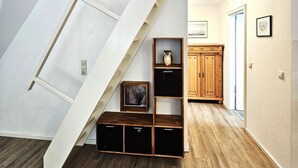 Ein Schlafzimmer im Loft-Stil mit einer Holztreppe, integrierten Regalen und Holzboden.