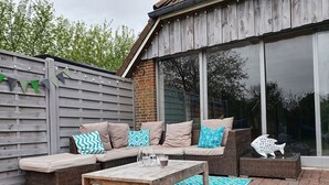 Eine Außenpatio mit einer Couch, einem Tisch und einer dekorativen Fischskulptur.