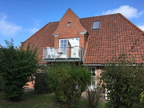 A house with a red-tiled roof, a brick chimney, and a small window. - Rungholtstr. 3 a - Upper floor right - Allergy-friendly apartment with balcony & (Wyk auf Föhr)