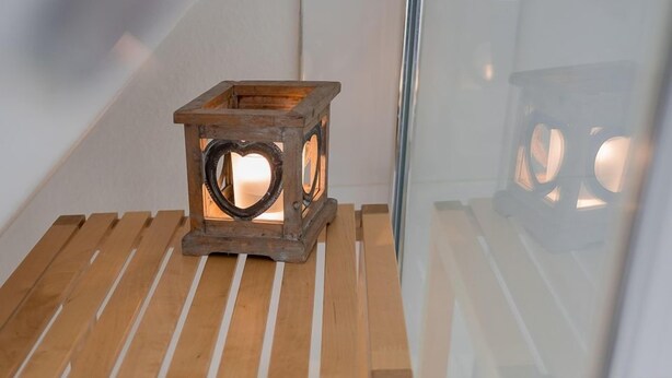 Una mesa de madera con una toalla azul y un farol.
