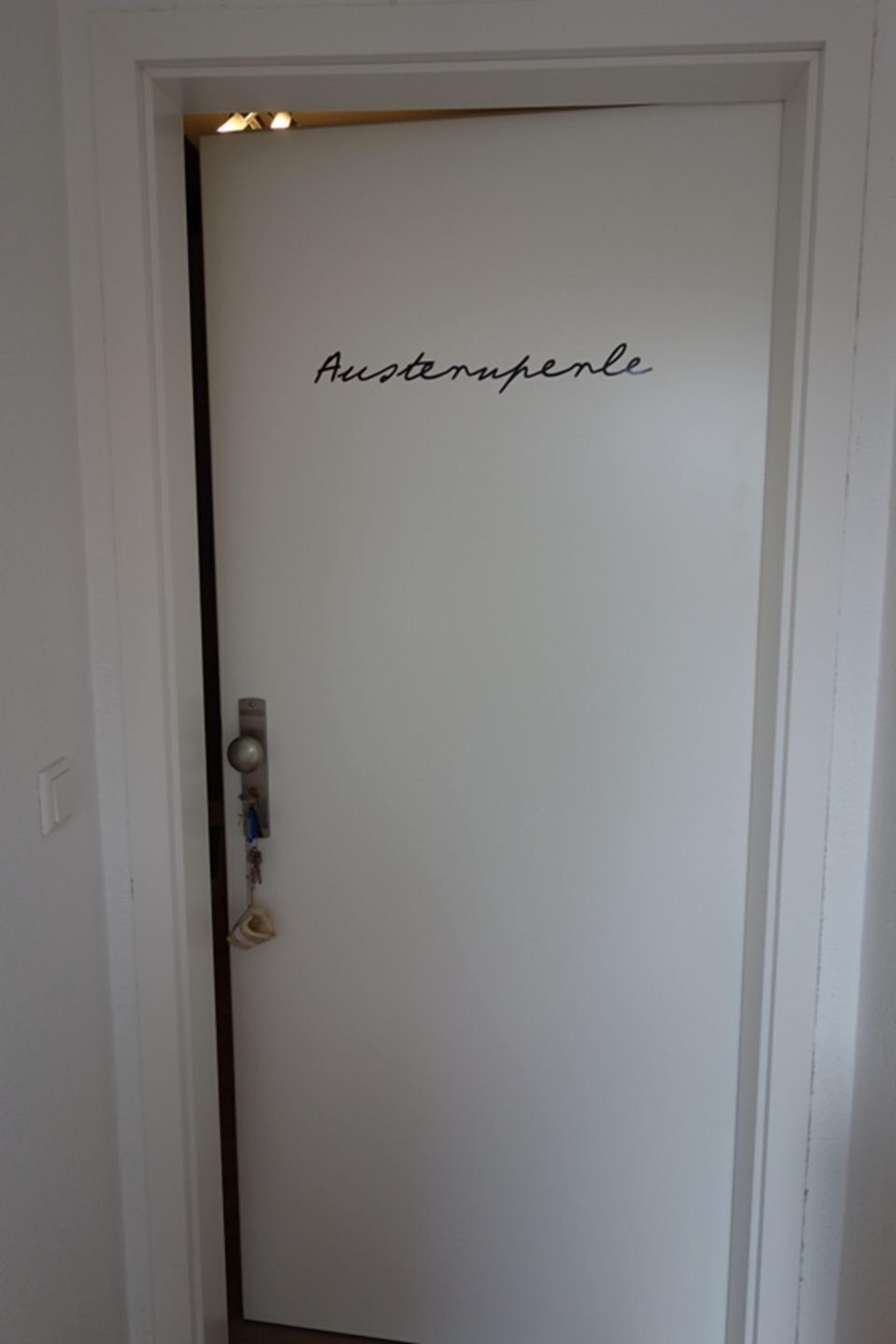 A white door with a keyhole and a padlock, and the text 'Austropferle' on it.