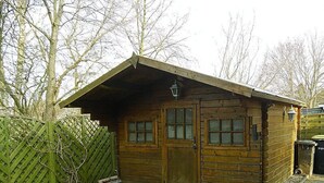 A wooden cabin with a sloped roof, two doors, and a small porch area. - Jordan - FW OG - Allergy-friendly vacation apartment with balcony in Wyk on Föhr, (Wyk auf Föhr)