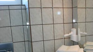 Ett badrum med toalett, handfat, handdukshängare och ett element.