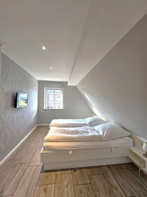 A bedroom with a bed, a TV, and a window. - Golfoase 1 - Semi-detached house for 6 people - Golfoase 1: Semi-detached house for 6 people (Oevenum)