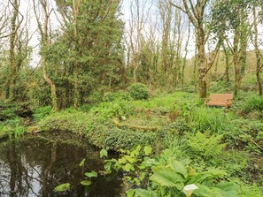 A natural landscape with a pond, dense greenery, and a wooden bench. - Seaview Retreat in Coverack (Coverack)