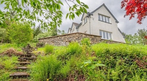 A house with a stone foundation, a steep stone staircase, and lush greenery. - Hazelseat House, Ulverston (Ulverston)