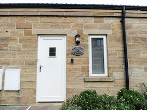 A stone building with a white door, a window with blinds, and a sign reading 'Kingfisher Cottage 3'. - Kingfisher Retreat in Whitby (Whitby)