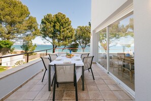 A table set for four with chairs, overlooking a coastal view with trees and a clear sky. - House with Stunning Sea Views Just Steps from Playa del Racó (Begur)