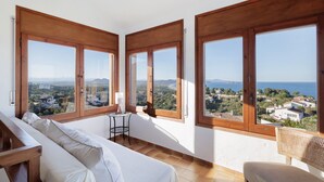 Un balcone con ampie finestre, un divano, un tavolino e una sedia.