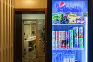 Un distributeur automatique rempli de boissons et d’en-cas, notamment de café glacé, de thé et de sodas.
