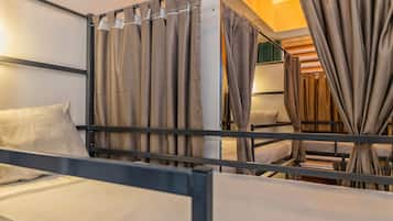 A bunk bed room with curtains, a bed, and a headboard.