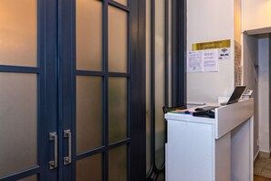 A reception desk with a laptop, a phone, and a notepad. There is a sign indicating a conference room and Wi-Fi availability. - TURQUOISE HOSTEL (Bucharest)