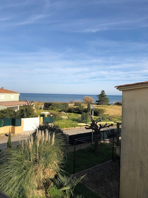 Un quartier résidentiel offrant une vue sur la mer, avec un chemin pavé et un lampadaire.