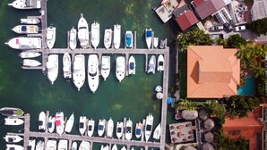 Un puerto deportivo con varias embarcaciones amarradas, un muelle de madera y un edificio de techo rojo.