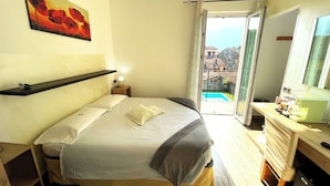 Une chambre à coucher avec un lit, une table de chevet, une lampe et un tableau au mur.