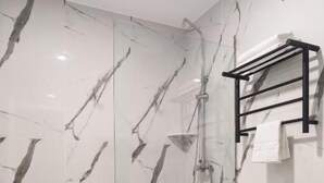 A modern bathroom with a glass shower enclosure, a white toilet, and a wooden vanity. - HOTEL GOLDEN (San Sebastián de los Reyes)