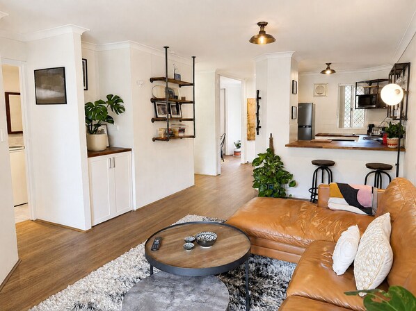 A modern living room with a leather sofa, a coffee table, and a small side table.