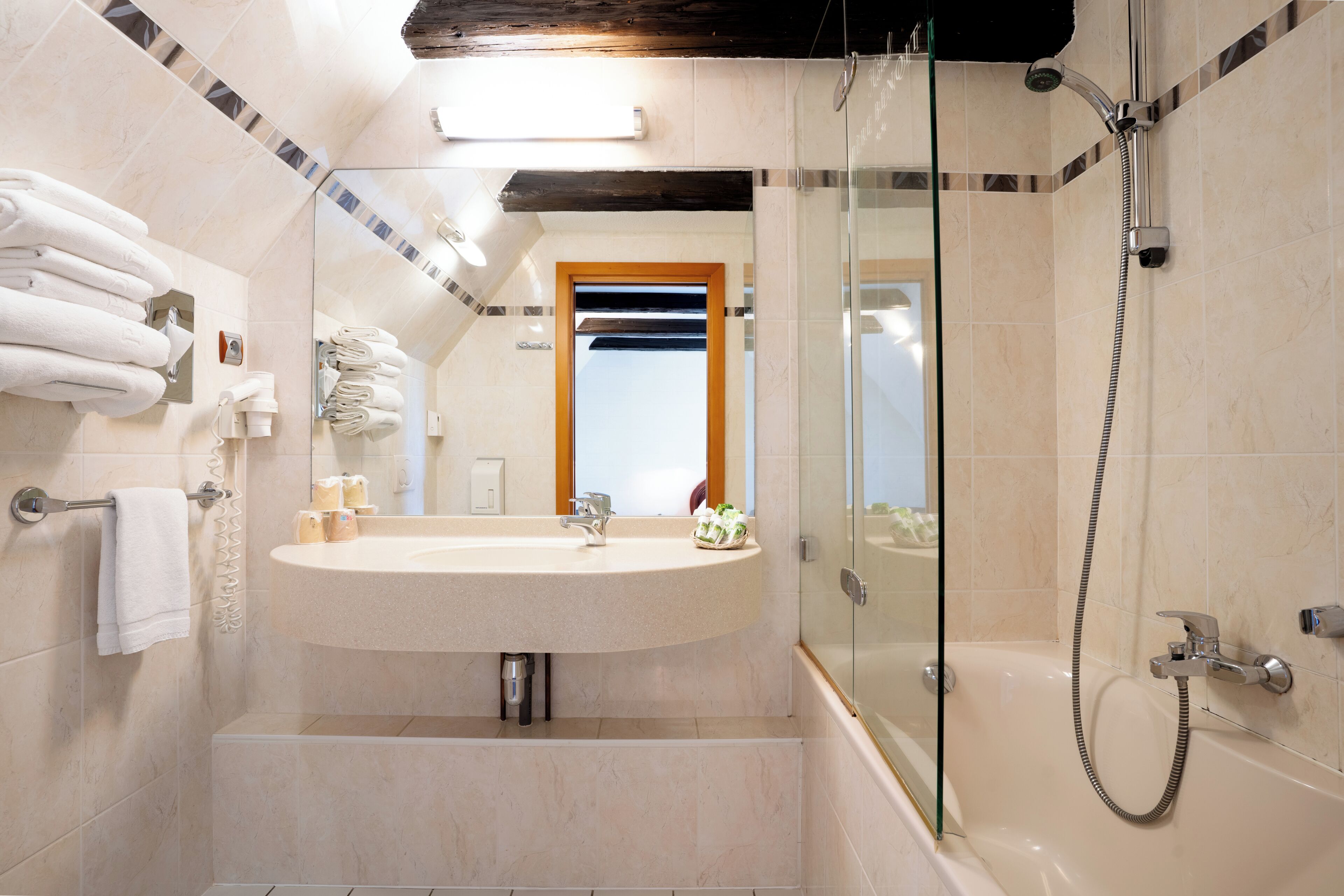 A bathroom with a sink, mirror, and shower.