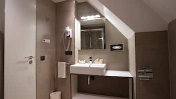 Ein modernes Badezimmer mit Dusche, Waschbecken und Spiegel.