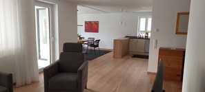 Un apartamento moderno con comedor, cocina y un amplio ventanal.