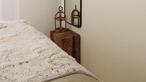 A bedroom with a wooden ceiling, a large mirror, and a small wooden stool. - Eulenschlupf, modern and lovely vacation apartment with garden and sauna (Ühlingen-Birkendorf)