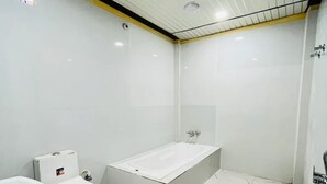 Une salle de bain équipée de toilettes, d’un bidet et d’une baignoire.