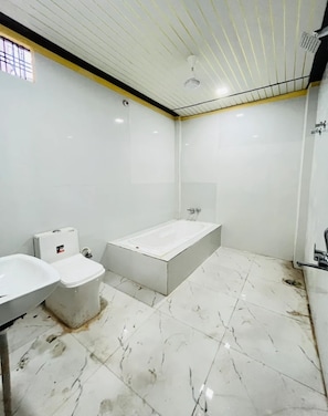 A bathroom with a toilet, bidet, and bathtub. - Hotel Basera  (Lucknow)