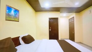 Une chambre d’hôtel avec un lit, une porte et un tableau accroché au mur.
