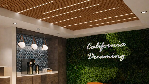A reception area with a wooden ceiling, a wall with a green leafy backdrop, and a sign that reads 'California Dreaming.' - La Quinta Inn and Suites by Wyndham Torrance Redondo Beach (Inglewood)