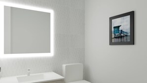A bathroom with a white sink, a toilet, and a framed picture on the wall. - La Quinta Inn and Suites by Wyndham Torrance Redondo Beach (Inglewood)