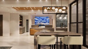 A modern interior with a wooden ceiling, a large TV screen, and a bar area. - La Quinta Inn and Suites by Wyndham Torrance Redondo Beach (Inglewood)