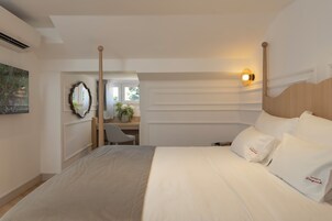 Quarto de hotel com uma cama grande, uma mesa e uma cadeira.