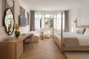 Quarto moderno com cama, escrivaninha, cadeira e um espelho grande.