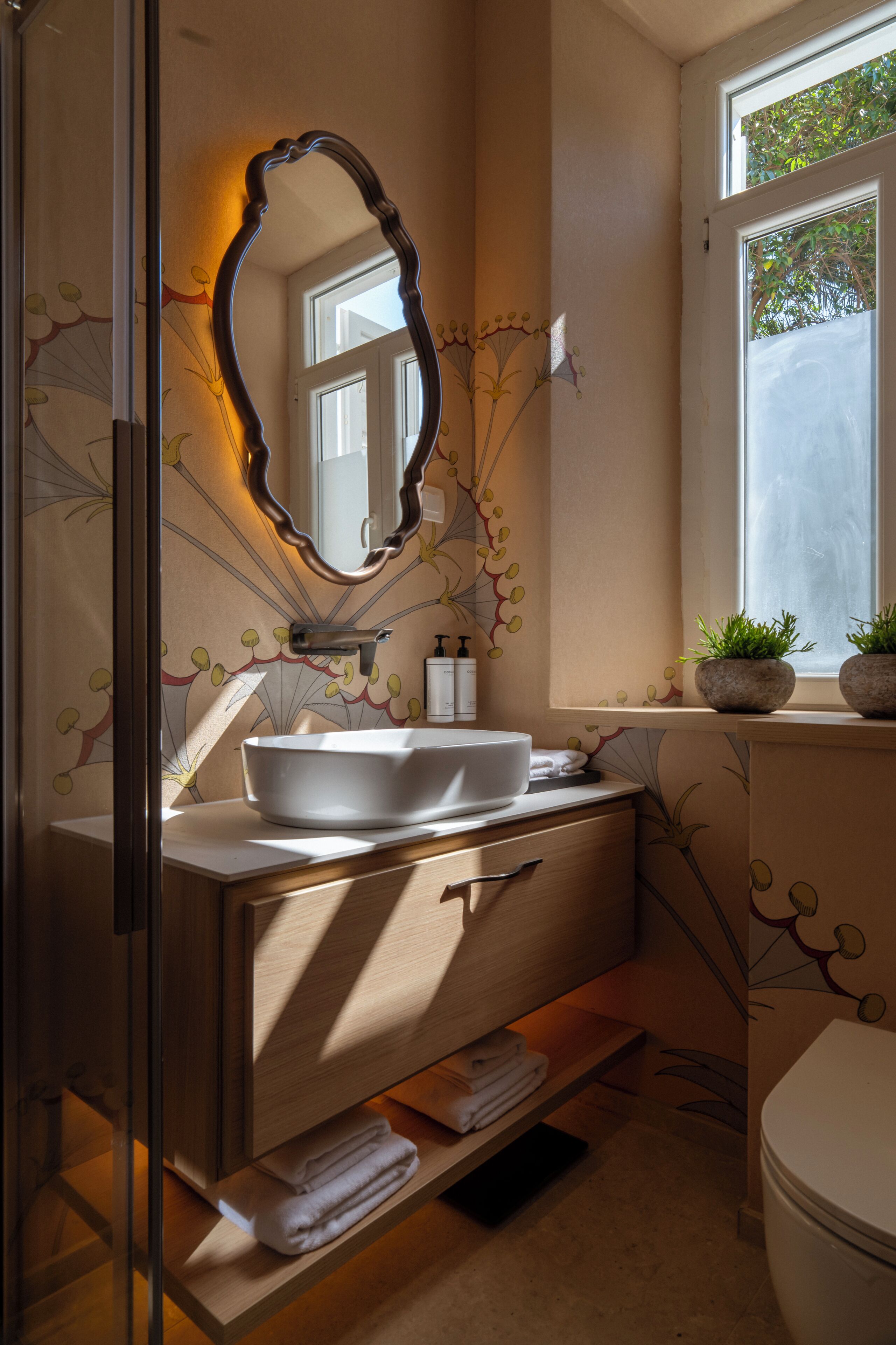 A bathroom with a vanity, a sink, a mirror, and a window.