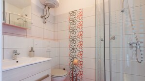 Ein Badezimmer mit Toilette, Waschbecken und Dusche.