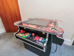 Eine Videospiel-Arcade-Maschine mit Weltall-Design, ausgestattet mit farbenfrohen Tasten und Joysticks.