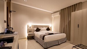Een moderne hotelkamer met een bed, nachtkastjes, een bureau en een kledingkast.