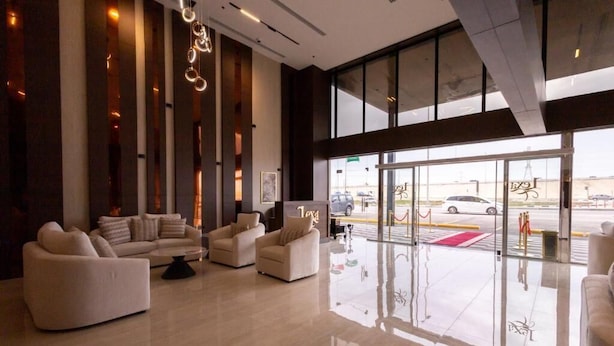 Een moderne lobby met een zithoek, grote ramen en uitzicht op de straat.