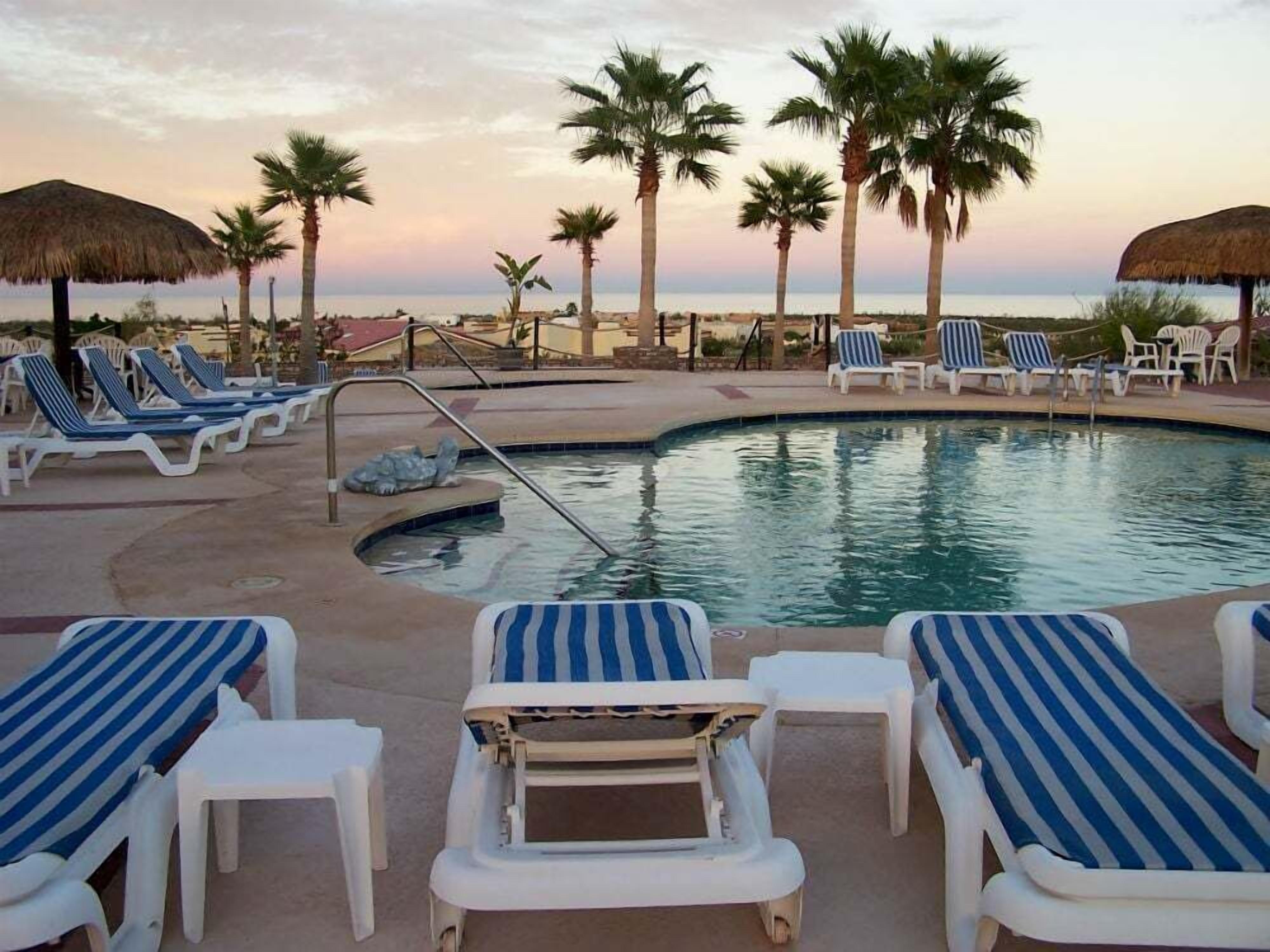 This image shows the private pool at Casita de Oro with several lounge chairs and a shaded palapa — perfect for cooling off between trips to the beach.