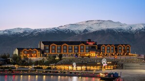 A multi-story building with a sign reading 'RAMADA' in front of a snow-covered mountain range. - Ramada by Wyndham Erzincan Ergan (Erzincan)