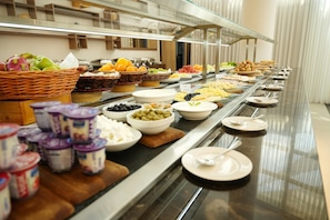 A buffet with various food items and condiments.