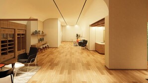 A modern interior with a wooden floor, a reception desk, and a seating area with chairs and a table. - Residence Inn by Marriott Guadalajara Country Club (Guadalajara)