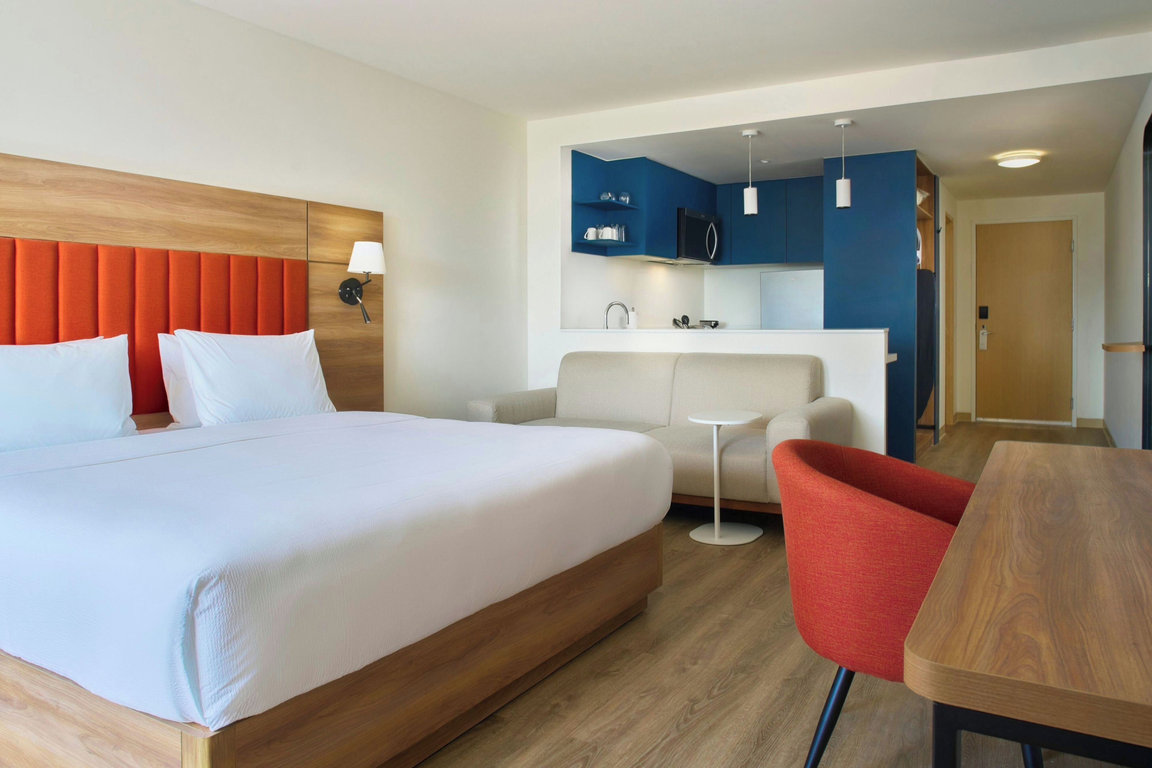 Une chambre d’hôtel comprenant un lit, un canapé, une table à manger et une kitchenette.