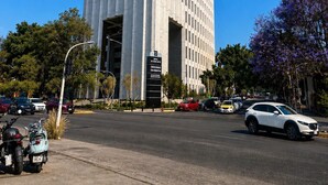 A tall, modern building with a grid-like facade, a prominent entrance, and a clear blue sky. - Residence Inn by Marriott Guadalajara Country Club (Guadalajara)