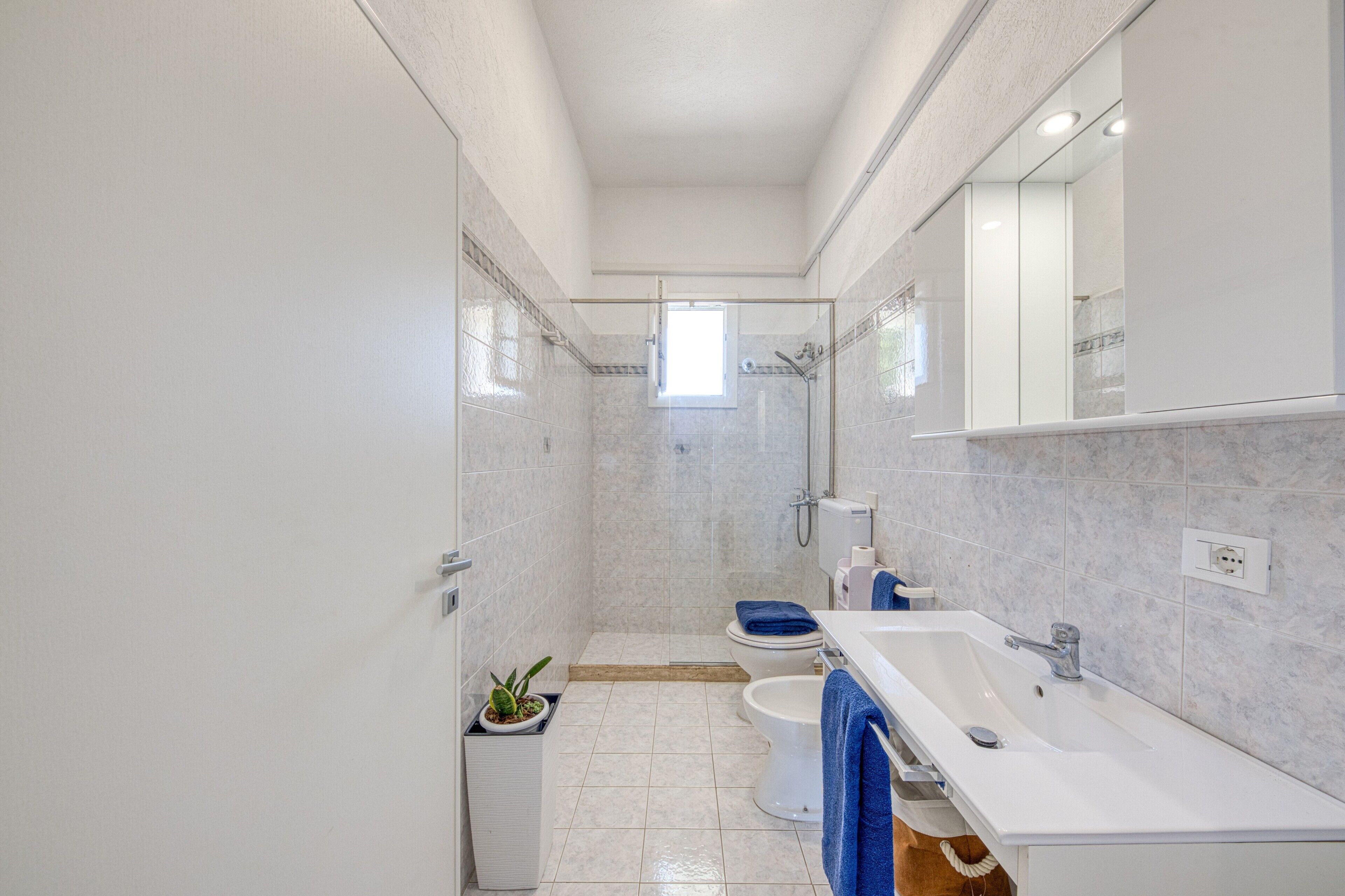 Une salle de bain moderne équipée d’une douche, de toilettes, d’un lavabo et d’un grand miroir.
