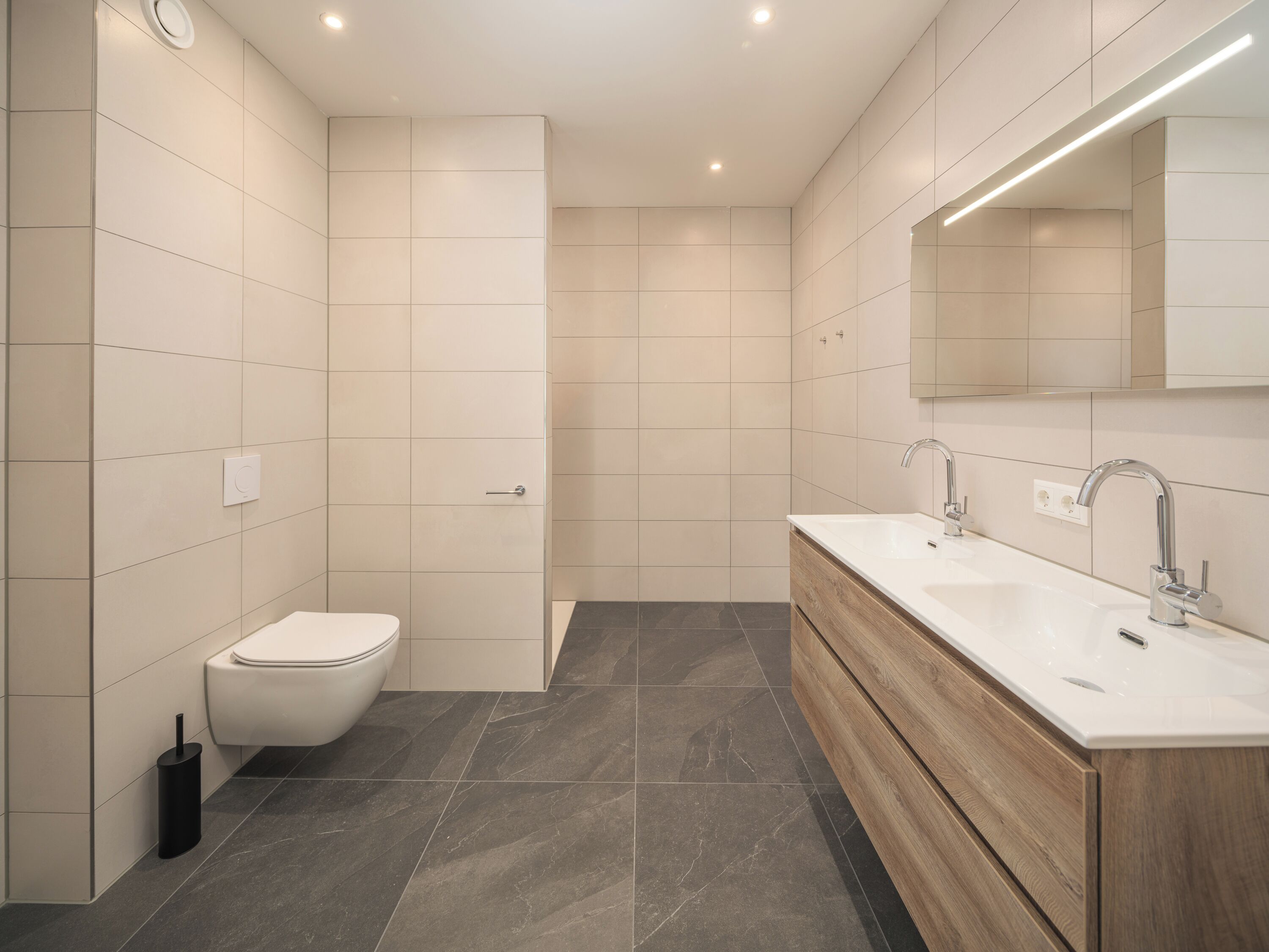 Ein modernes Badezimmer mit Toilette, Bidet und Waschtisch mit Spiegel.