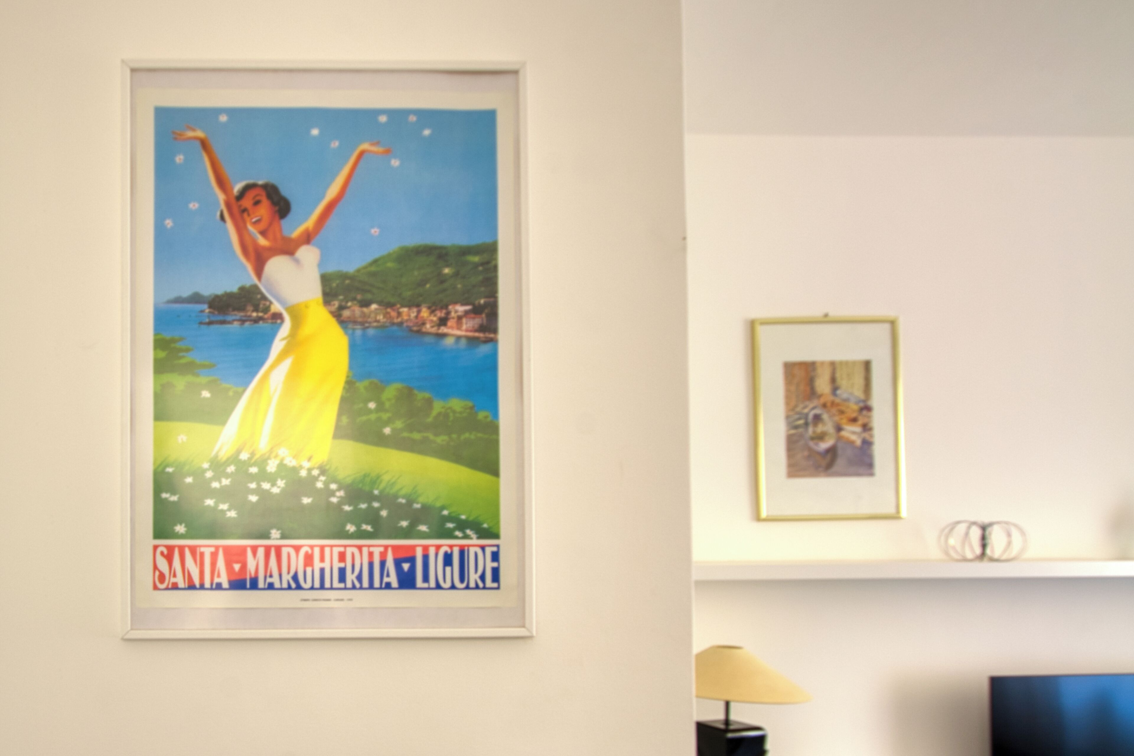 A framed poster of a woman dancing with the text 'Santa Margherita Ligure' on a wall.