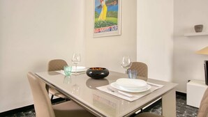 Een eettafel gedekt met borden, glazen en een kom, met daarboven een lijst met een foto.